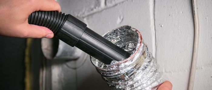 Dryer vent cleaning service — removing lint buildup from flexible aluminum dryer vent hose to prevent house fires
